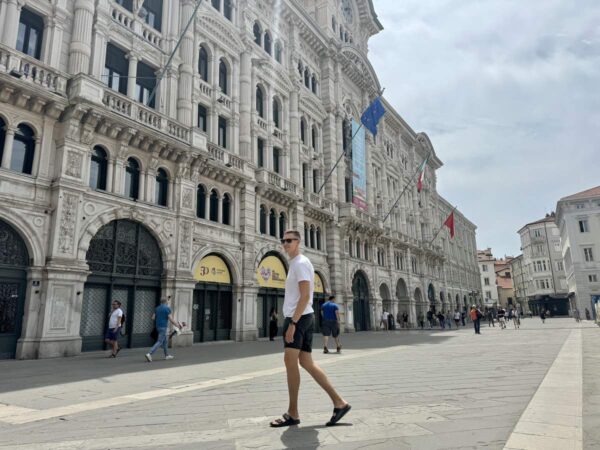 Man Walking In Front Of Historic Building