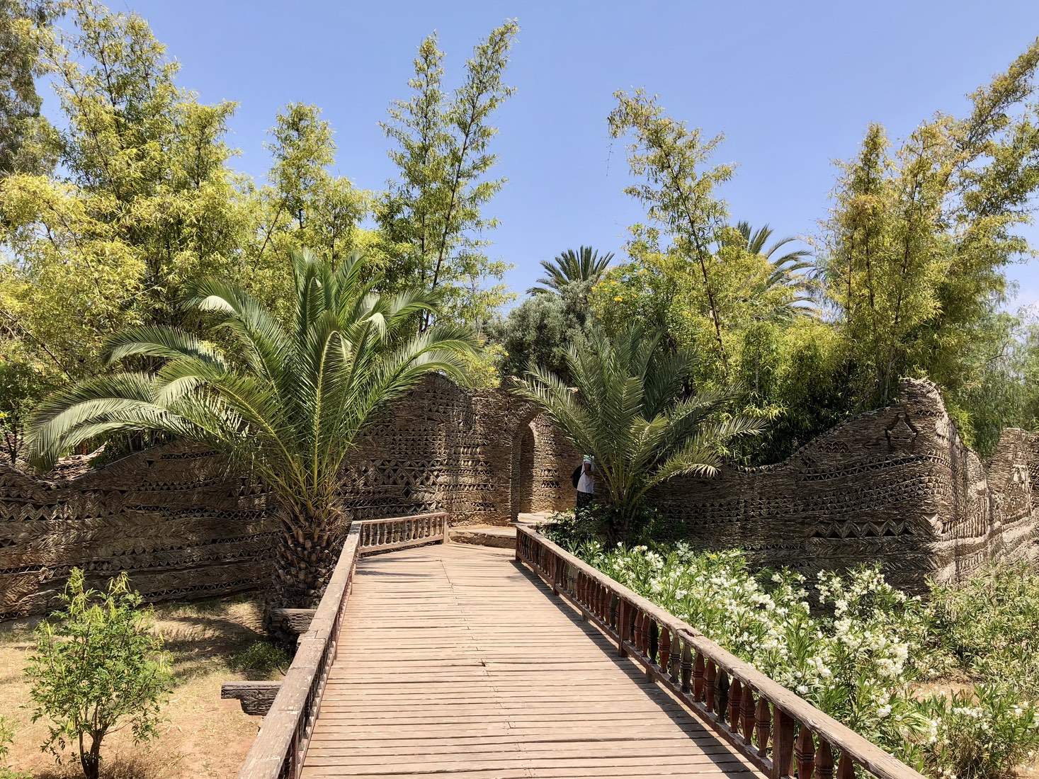 Wooden bridge path leading into a lush garden at Medina Polizzi Agadir Wooden bridge path leading into a lush garden at Medina Polizzi, Agadir